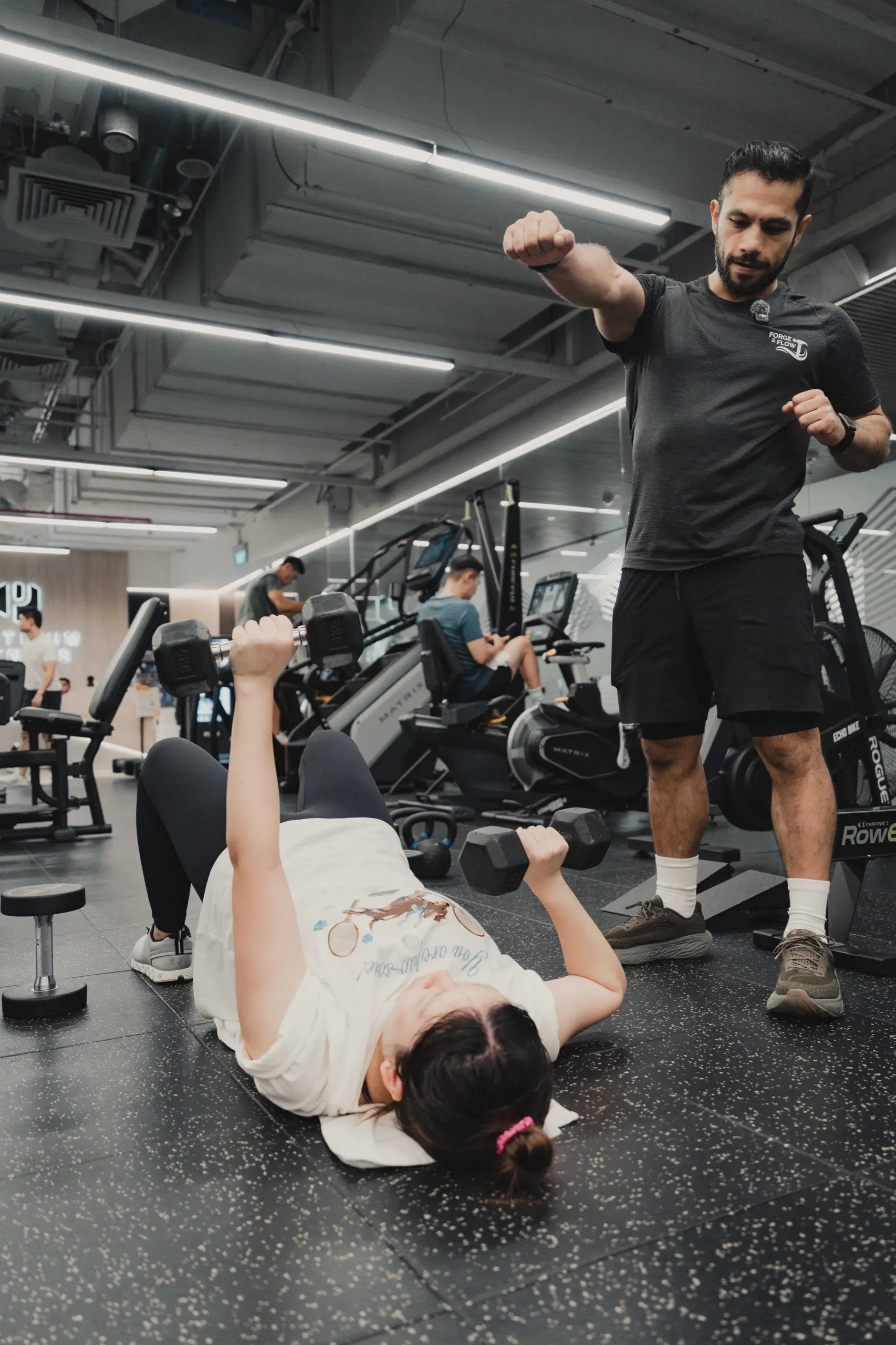 Ivan Figueroa coaching a client through a dumbbell floor press