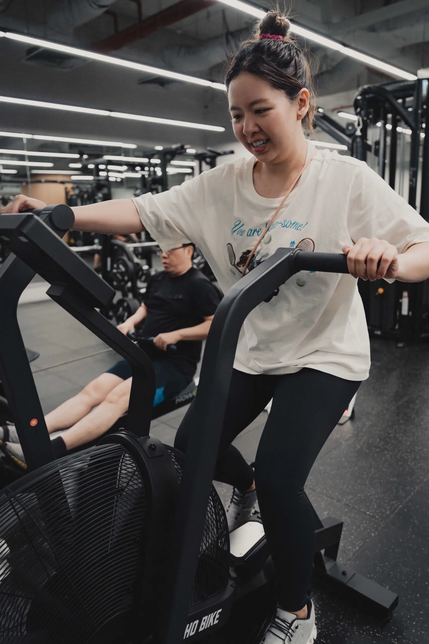 A client working hard on an air bike during a coached session